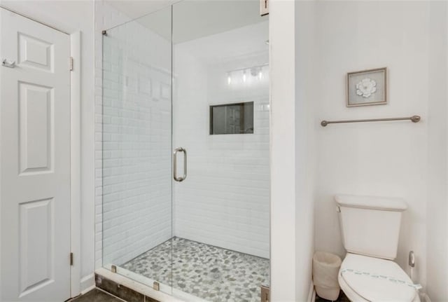 bathroom featuring walk in shower and toilet