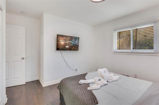 bedroom with dark hardwood / wood-style floors