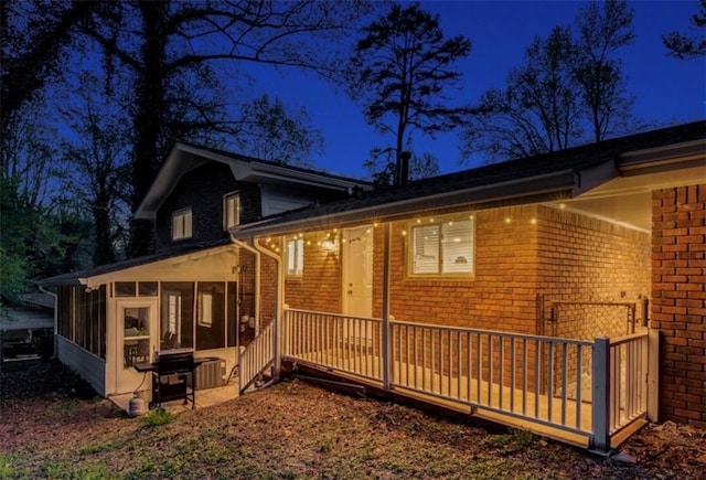 property exterior at twilight with a sunroom