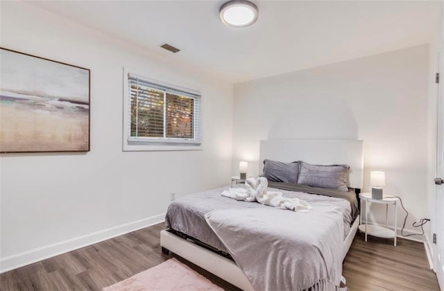 bedroom with dark hardwood / wood-style flooring