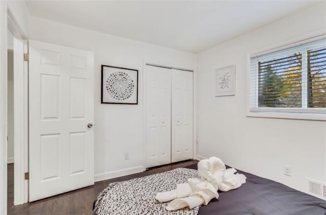 bedroom featuring dark hardwood / wood-style floors and a closet