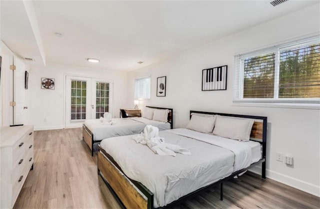 bedroom featuring french doors, access to exterior, and light hardwood / wood-style floors