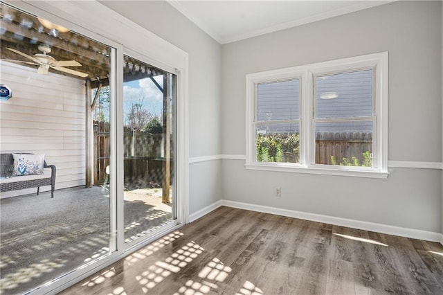 interior space with ornamental molding, ceiling fan, baseboards, and wood finished floors