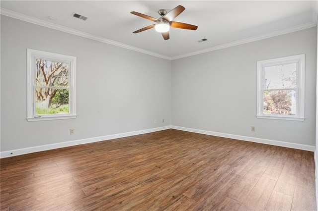 unfurnished room featuring dark wood finished floors, visible vents, plenty of natural light, and baseboards