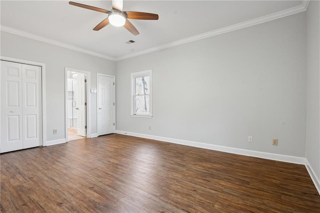 unfurnished bedroom with dark wood finished floors, visible vents, baseboards, and ornamental molding