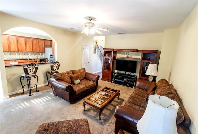 carpeted living room with ceiling fan