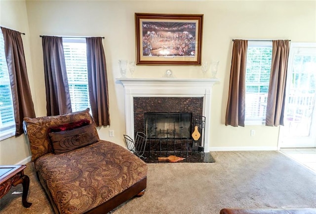 sitting room with carpet and a high end fireplace