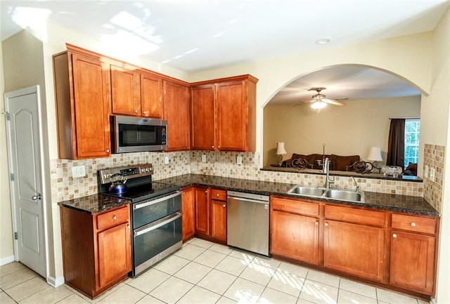 kitchen featuring sink, light tile patterned floors, appliances with stainless steel finishes, and decorative backsplash