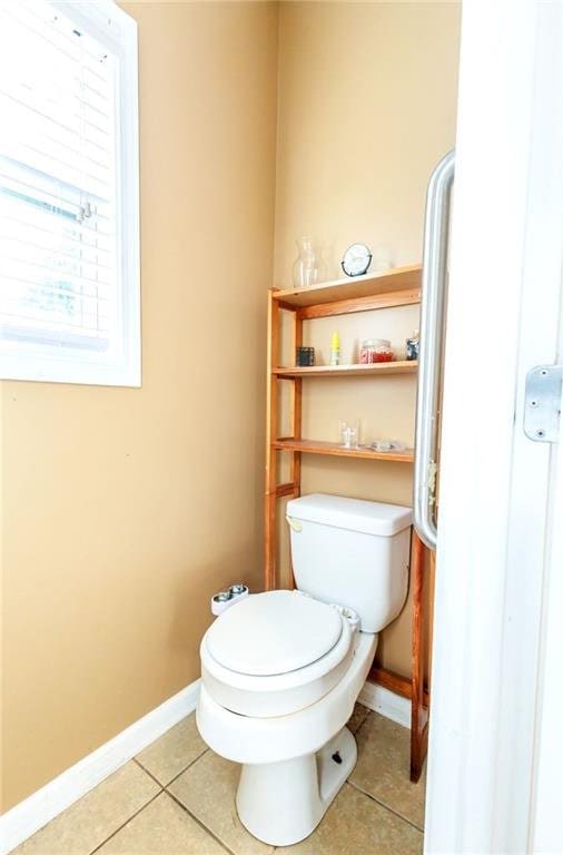 bathroom with toilet and tile patterned flooring