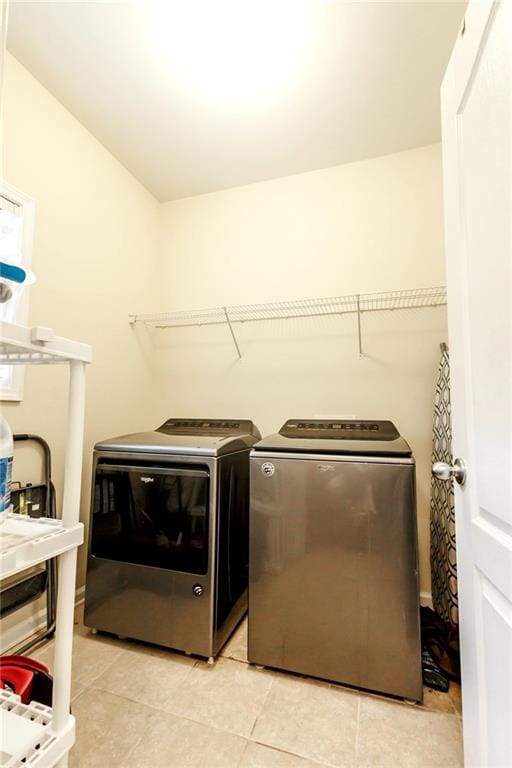 laundry room with light tile patterned floors and washing machine and clothes dryer