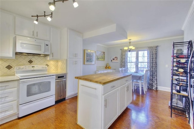 kitchen with crown molding, white appliances, white cabinetry, and pendant lighting