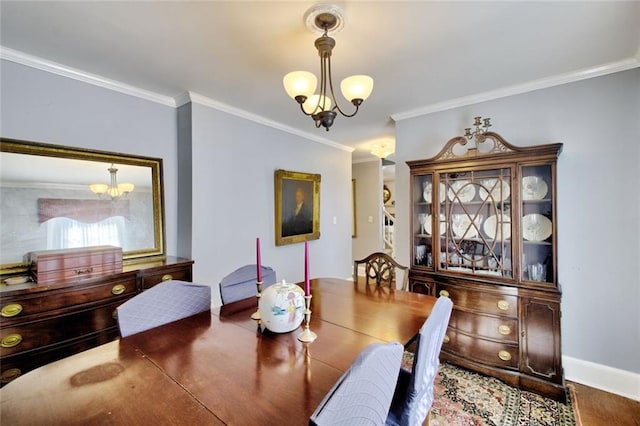 dining space with a chandelier, crown molding, and baseboards