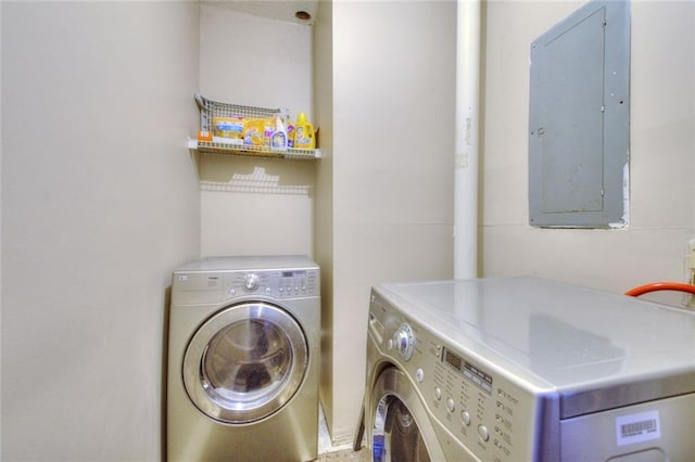 laundry room with laundry area, washing machine and dryer, and electric panel