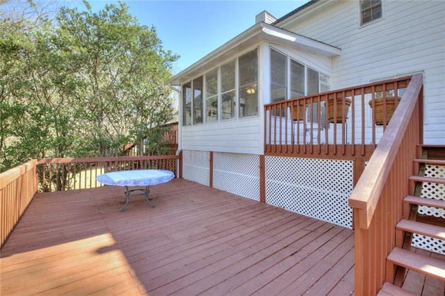 deck featuring a sunroom and stairway