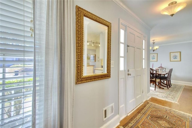 entrance foyer with baseboards, visible vents, a wealth of natural light, and ornamental molding