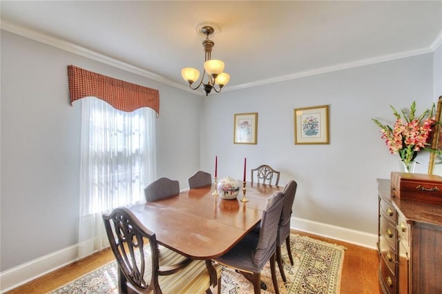 dining area featuring a notable chandelier, crown molding, baseboards, and wood finished floors