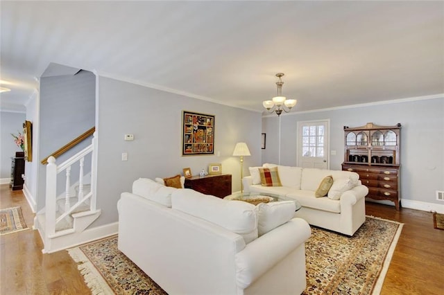 living area featuring stairway, wood finished floors, and ornamental molding