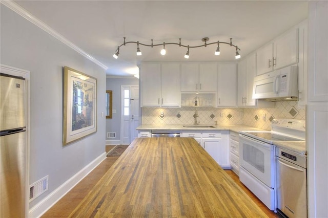 kitchen featuring stainless steel appliances, visible vents, decorative backsplash, white cabinetry, and a sink