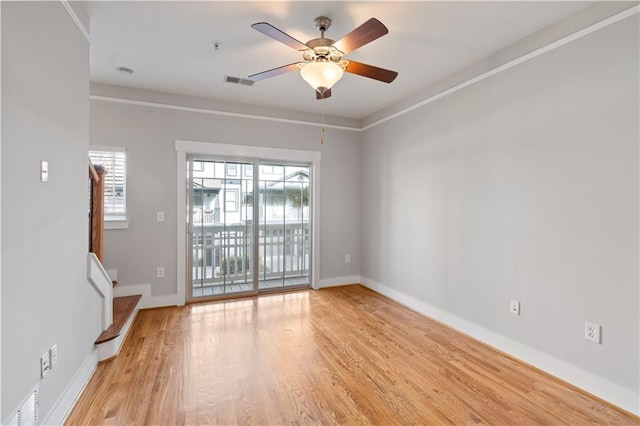 spare room featuring ceiling fan, crown molding, and light wood-type flooring