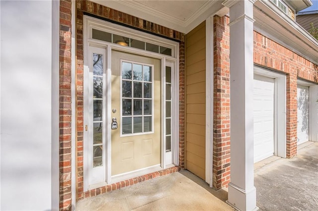 property entrance with a porch, a garage, and brick siding