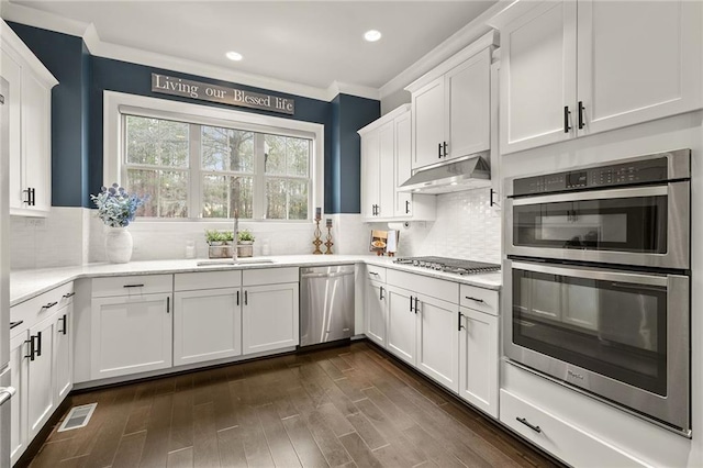 kitchen with stainless steel appliances, visible vents, white cabinets, a sink, and under cabinet range hood