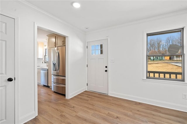 entrance foyer with light wood-style flooring, baseboards, and crown molding