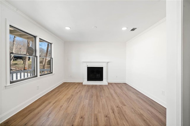 unfurnished living room featuring a fireplace, wood finished floors, visible vents, baseboards, and crown molding