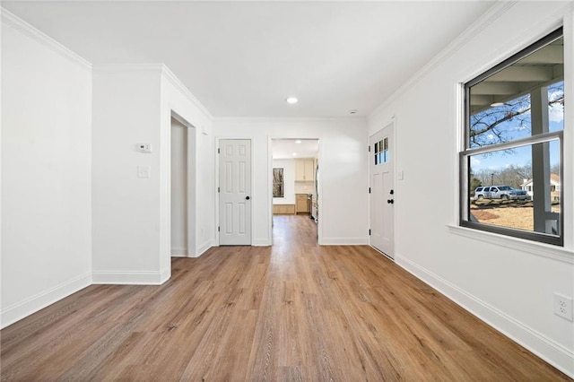 interior space featuring recessed lighting, crown molding, light wood finished floors, and baseboards