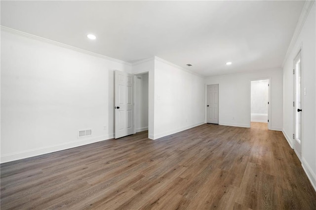 unfurnished room featuring baseboards, wood finished floors, and crown molding