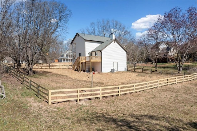 view of yard with fence, stairway, a deck, and a rural view