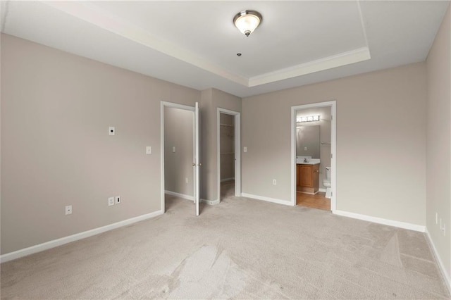 426 Pembrooke Cir Unit 426, Alpharetta, GA 30004 - unfurnished bedroom featuring light colored carpet, a walk in closet, baseboards, and a raised ceiling