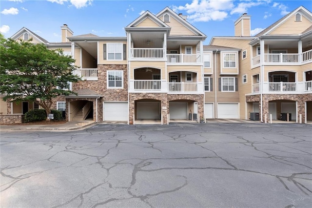 426 Pembrooke Cir Unit 426, Alpharetta, GA 30004 - view of building exterior featuring an attached garage, driveway, and central AC unit