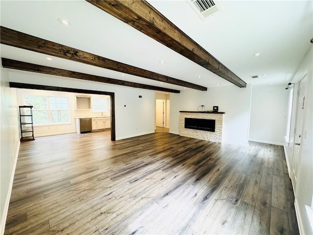 unfurnished living room featuring hardwood / wood-style flooring and beam ceiling