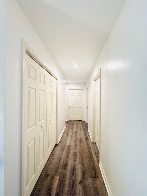 hallway with hardwood / wood-style floors