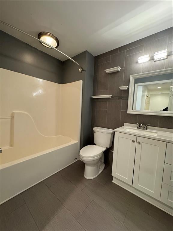 full bathroom with vanity, tile walls, bathing tub / shower combination, and toilet