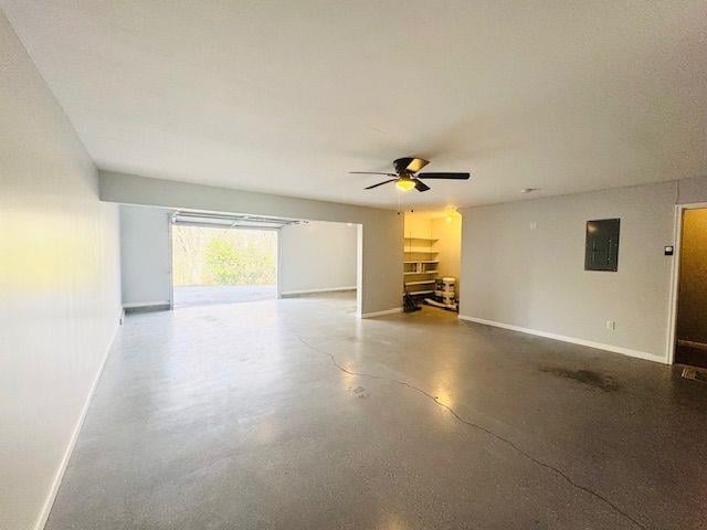 interior space with electric panel, concrete floors, and ceiling fan