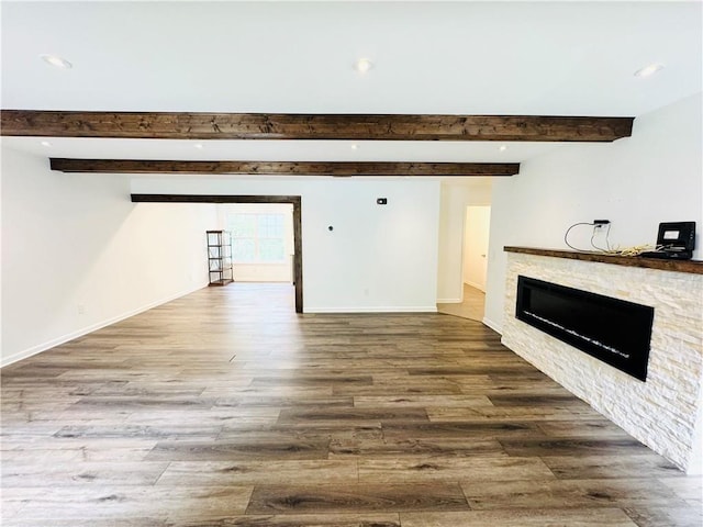 unfurnished living room featuring beam ceiling and hardwood / wood-style flooring