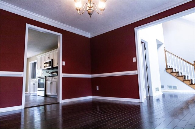 unfurnished room with a textured ceiling, ornamental molding, a chandelier, and dark hardwood / wood-style flooring