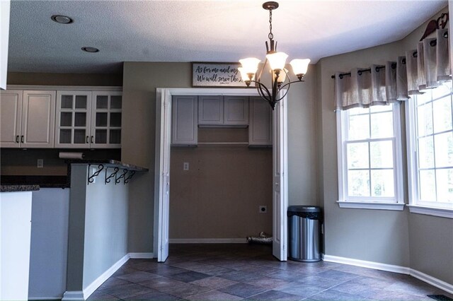 kitchen with pendant lighting, an inviting chandelier, and white cabinets