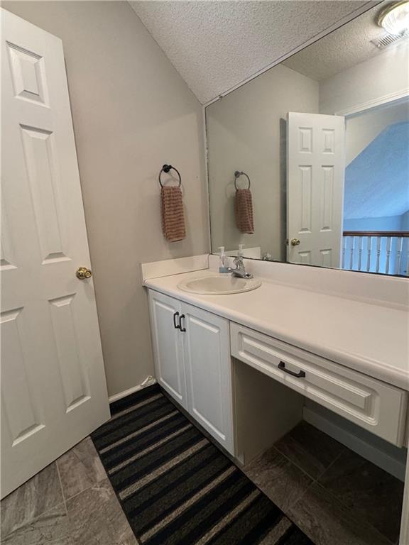 bathroom with vanity and a textured ceiling