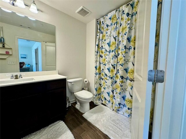 1606 Larkspur Trl, Conyers, GA 30012 - bathroom with wood finished floors, toilet, vanity, and a shower with shower curtain