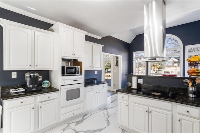 kitchen with black stovetop, marble finish floor, stainless steel microwave, white cabinetry, and oven