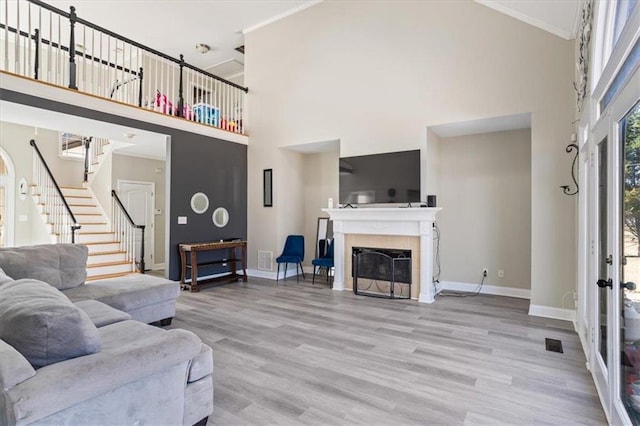 living room featuring stairs, baseboards, and wood finished floors