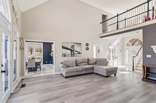 living area featuring light wood-type flooring, french doors, visible vents, and stairway