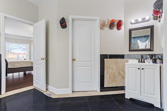 bathroom with baseboards, tile patterned flooring, vanity, and connected bathroom