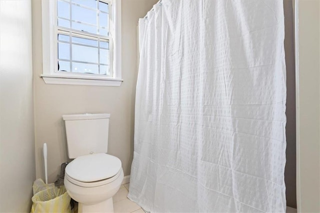 full bath featuring toilet, curtained shower, and tile patterned floors