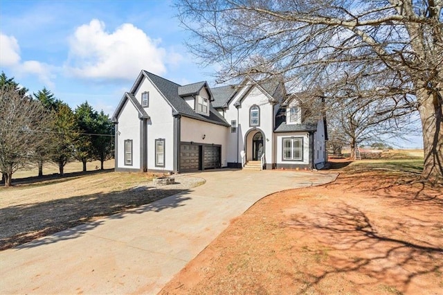 view of front of property featuring concrete driveway, an attached garage, and stucco siding