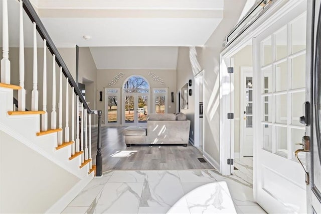 foyer entrance featuring baseboards, stairway, marble finish floor, vaulted ceiling, and french doors