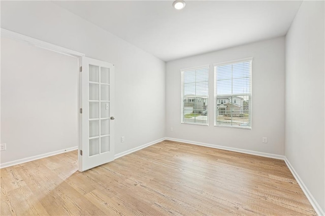 unfurnished room with light wood-style floors and baseboards