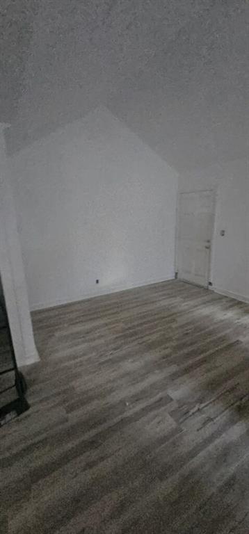 bonus room featuring dark wood-type flooring and a textured ceiling